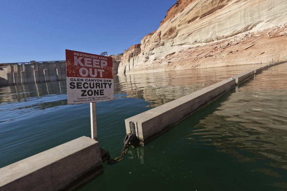 FILE - A sign reading "keep out" is displayed just upstream of Glen Canyon Dam at Lake Powell, June 8, 2022, in Page, Ariz. As America's large reservoirs on the Colorado River drop to record-low levels, fish are among those suffering the impact. (AP Photo/Brittany Peterson, File)