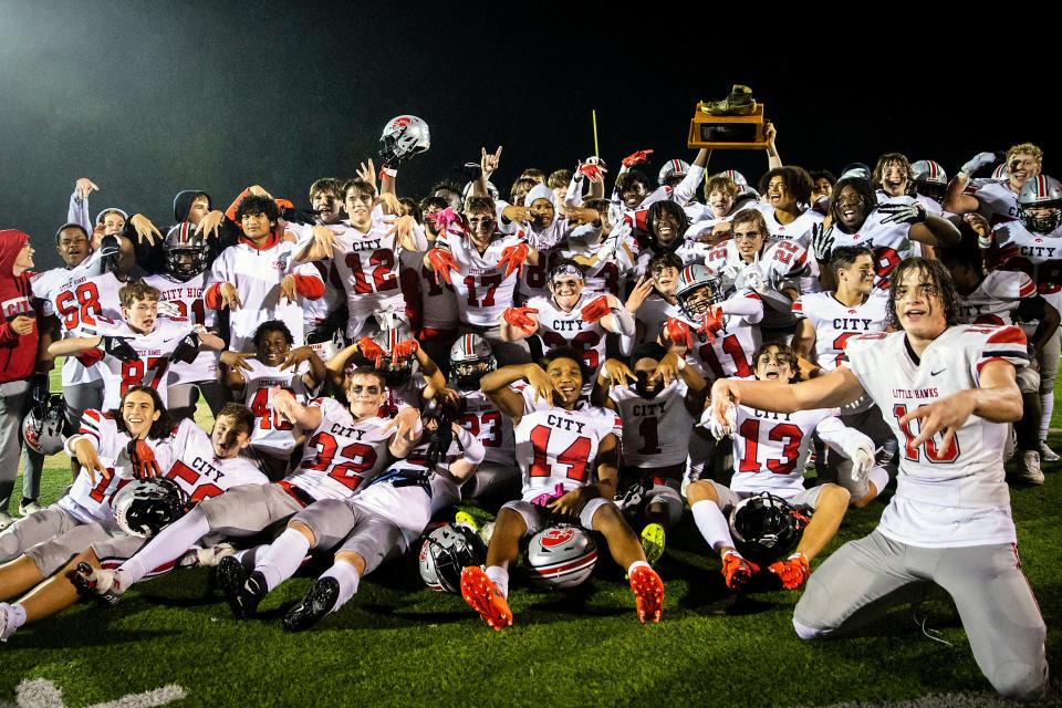 Iowa City High players pose for a photo with the Boot trophy after a win over rival Iowa City West on Friday at Trojan Field. The Little Hawks won 49-0.