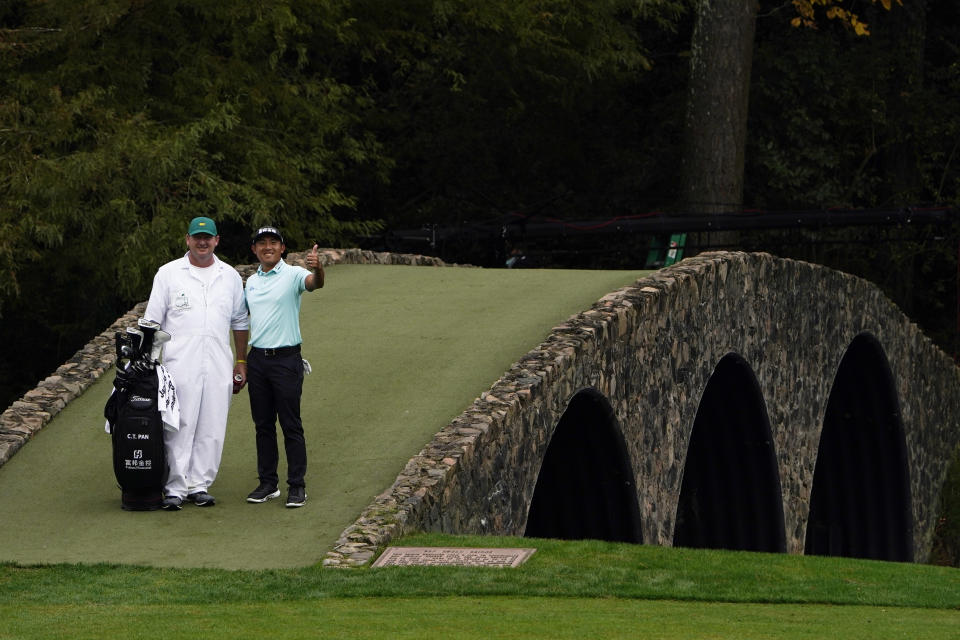 C.T. Pan, of Taipei, poses with his caddie on the Ben Hogan Bridge during a practice round for the Masters golf tournament Tuesday, Nov. 10, 2020, in Augusta, Ga. (AP Photo/Chris Carlson)