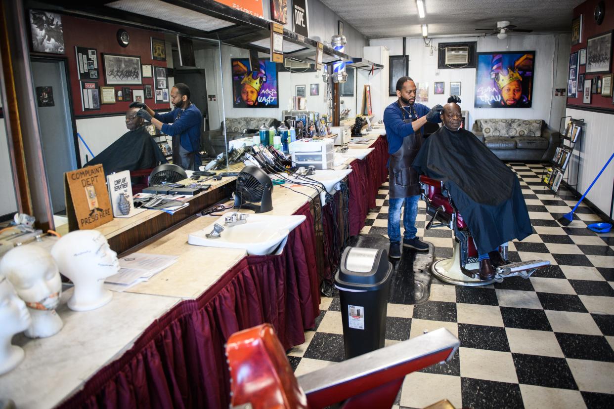 Travis Fowler shaves Robert Owens' head at Midway Barber Shop at 4521 Bragg Blvd.