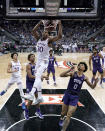 Kansas guard Ochai Agbaji (30) gets past TCU guard Micah Peavy (0) to put up a shot during the second half of an NCAA college basketball game in the semifinal round of the Big 12 Conference tournament in Kansas City, Mo., Friday, March 11, 2022. Kansas won 75-62. (AP Photo/Charlie Riedel)