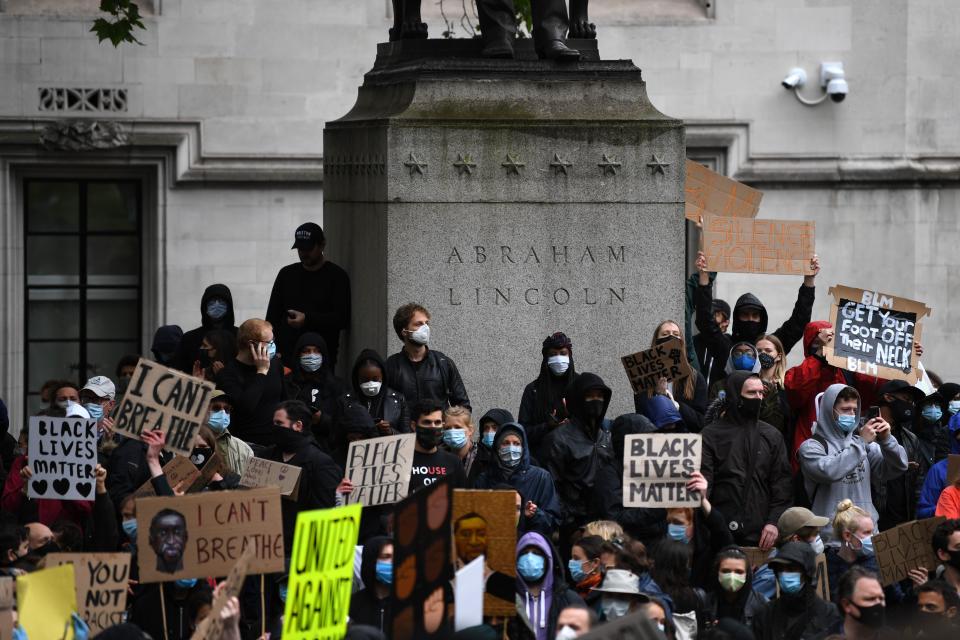 Protesters hold placards as they attend a demonstration in Parliament Square in central London on June 6, 2020, to show solidarity with the Black Lives Matter movement in the wake of the killing of George Floyd, an unarmed black man who died after a police officer knelt on his neck in Minneapolis. - Taking a knee, chanting and ignoring social distancing measures, outraged protesters from Sydney to London kicked off a weekend of global rallies Saturday against racism and police brutality. (Photo by DANIEL LEAL-OLIVAS / AFP) (Photo by DANIEL LEAL-OLIVAS/AFP via Getty Images)