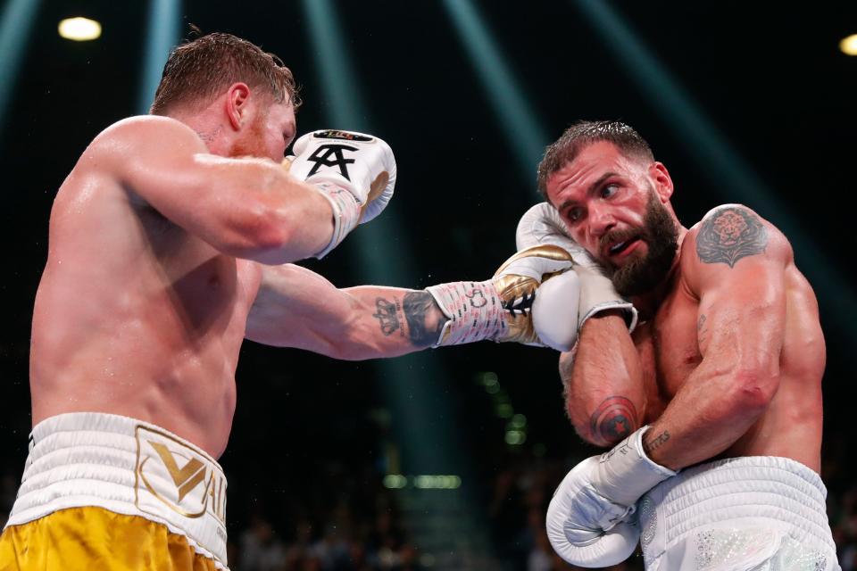 Canelo Alvarez, of Mexico, hits Caleb Plant during a super middleweight title unification fight (AP)