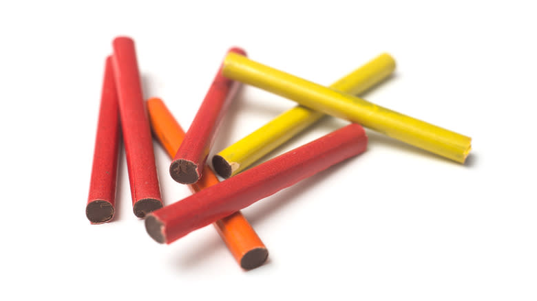 Multicolored chocolate cigarettes on white background