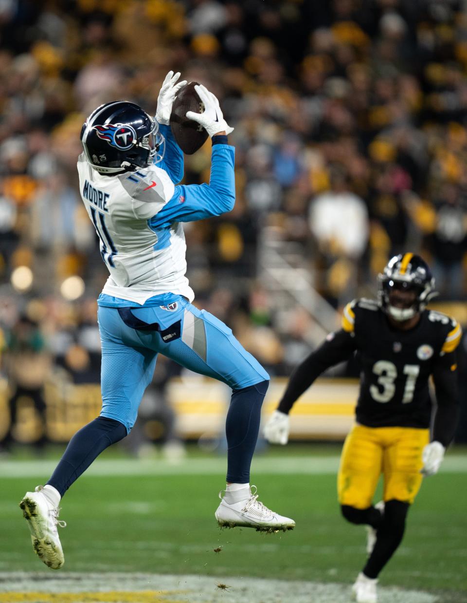 Tennessee Titans wide receiver Chris Moore (11) hauls in a long reception in front of Pittsburgh Steelers safety Elijah Riley (37) during the fourth quarter of their game at Acrisure Stadium in Pittsburgh, Penn., Thursday, Nov. 2, 2023.