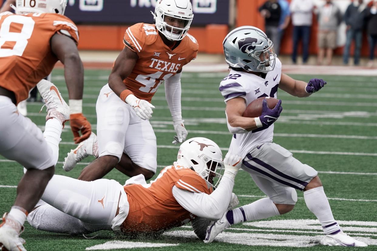 Texas defensive end Jacoby Jones (3) pulls down Kansas State's Deuce Vaughn (22) during the second half Saturday at Darrell K Royal-Texas Memorial Stadium.