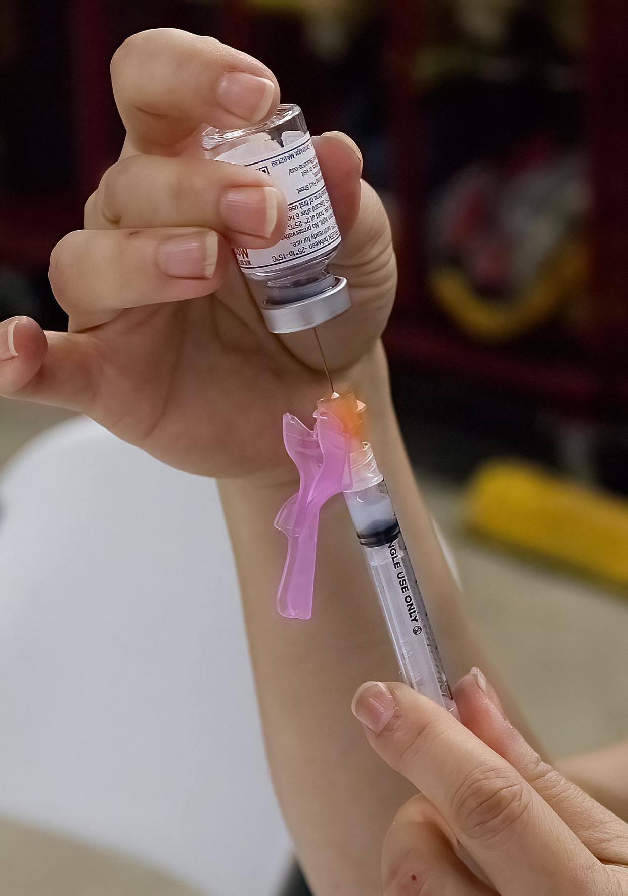 Portage County Health Department Public Health Nurse Mamie Sawyer-Brewer fills a syringe preparing for a COVID-19 vaccine.