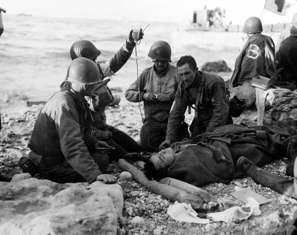 FILE - In this June 1944, file photo, U.S. Army medical personnel administer a transfusion to a wounded comrade, who survived when his landing craft went down off the coast of Normandy, France, in the early days of the Allied landing operations. A dwindling number of D-Day veterans will be on hand in Normandy in June 2019, when international leaders gather to honor them on the invasion’s 75th anniversary. (U.S. Army Signal Corps via AP, File)
