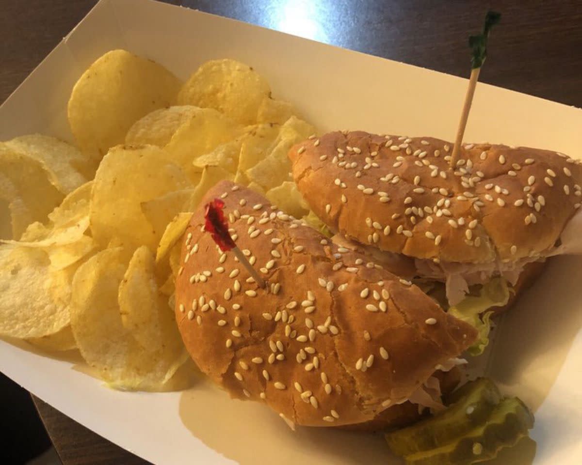 Roast Turkey Sandwich with potato chips in a cardboard serving boat, Bates House of Turkey, Greenville, Alabama, on a table