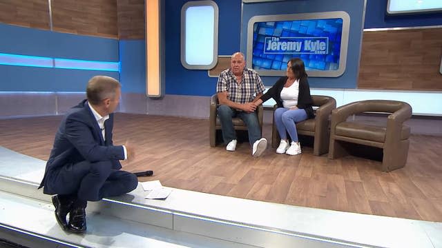 Jeremy Kyle sitting on the edge of the stage, with Steve Dymond and his partner behind him