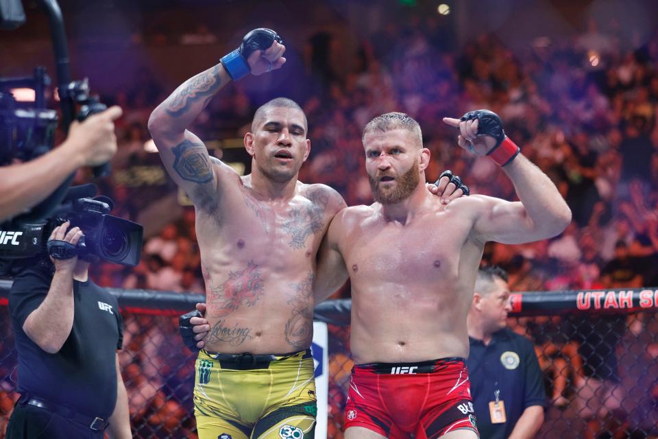 Jan Blachowicz (red gloves) and Alex Pereira (blue gloves) react after their fight during UFC 291 at Delta Center.