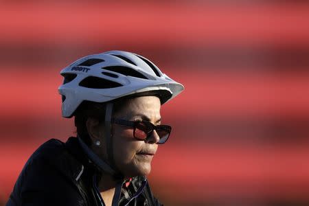 Brazil's President Dilma Rousseff rides her bicycle near the Alvorada Palace in Brasilia, July 27, 2015. REUTERS/Ueslei Marcelino