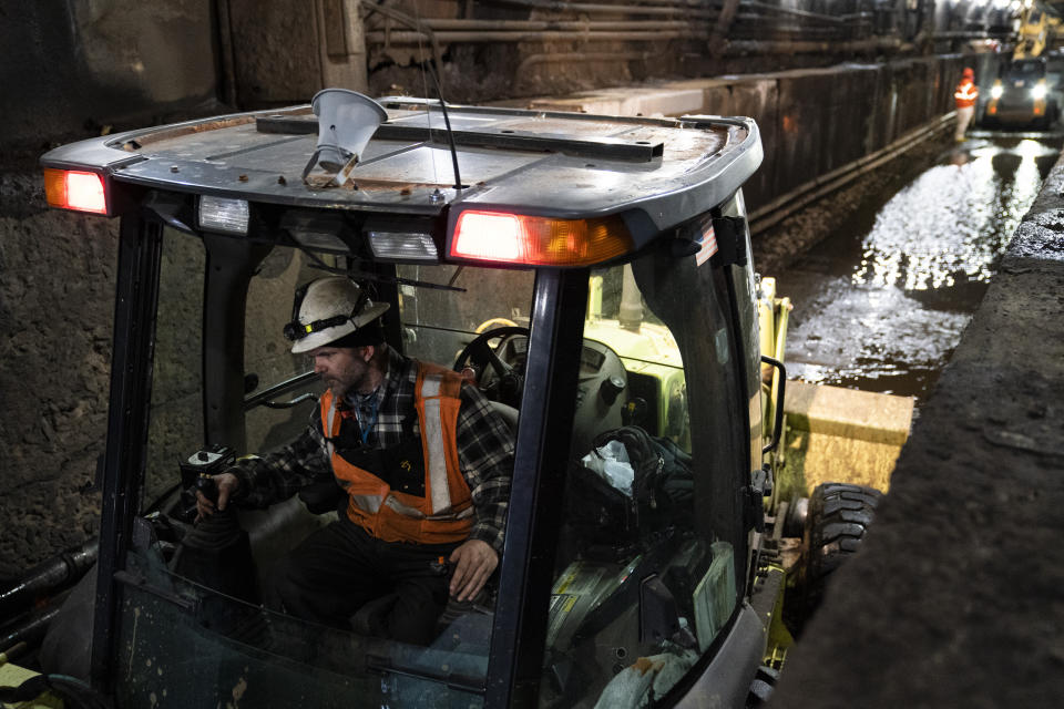 Amtrak workers perform tunnel repairs to a partially flooded train track bed, Saturday, March 20, 2021, in Weehawken, N.J. With a new rail tunnel into New York years away at best, Amtrak is embarking on an aggressive and expensive program to fix a 110-year-old tunnel in the interim. (AP Photo/John Minchillo)