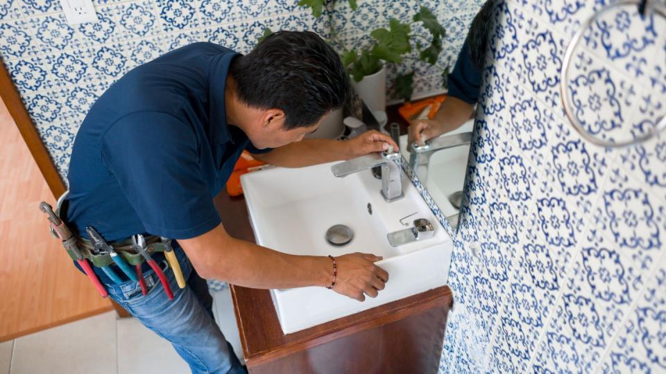 plumber installing a faucet in a bathroom's sink