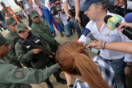 Colombia's President Juan Manuel Santos (R) greets Venezuela's national guards during a visit to Paraguachon border with Venezuela, Colombia, September 15, 2015, in this handout photo provided by Colombian Presidency. REUTERS/Efrain Herrera/Colombian Presidency/Handout via Reuters