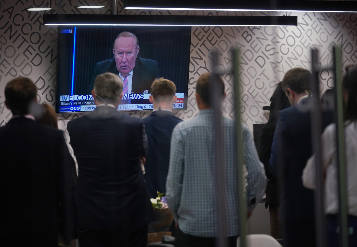 Staff in the green room watching a television screen showing presenter Andrew Neil broadcast from a studio, during the launch event for new TV channel GB News at The Point in Paddington, London. Picture date: Sunday June 13, 2021.