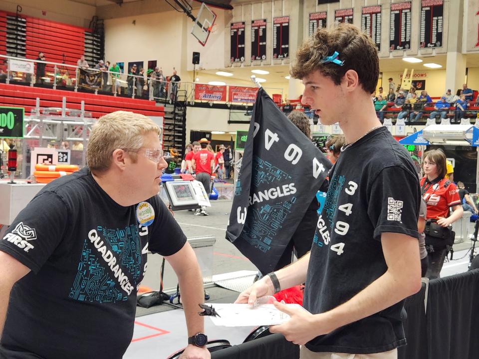 Chris Hacker, left, talks with Quadrangles team member Emerson Bessler at the F.I.R.S.T. Indiana Robotics state championship in Lafayette, Indiana, in early April.