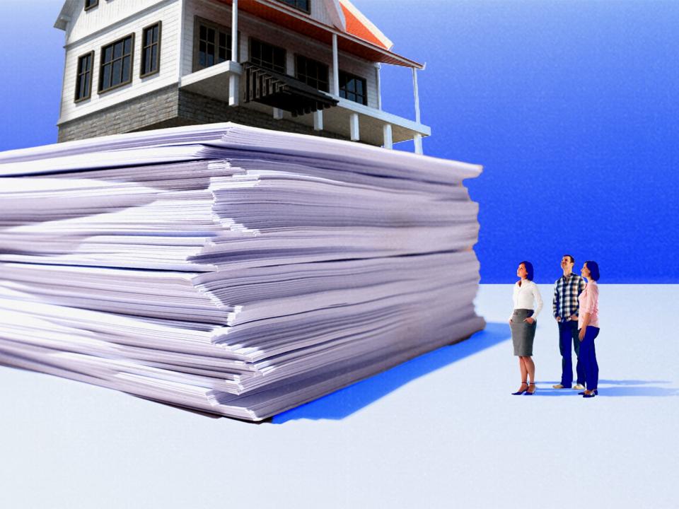 Realtor and prospective home buyers look up at a stack of documents with a house on top