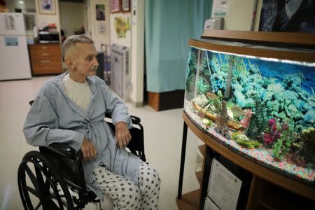 Inmate Joseph Morrow, 69, who has bladder cancer, looks at a fish tank in the hospice at the California Medical Facility prison in Vacaville, California, U.S., May 22, 2018. REUTERS/Lucy Nicholson