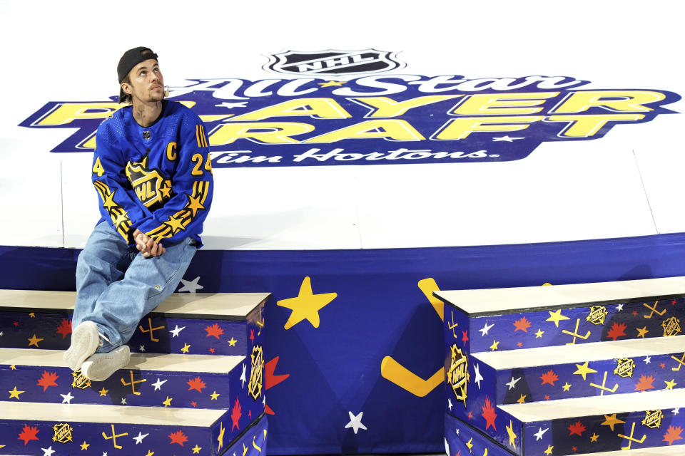 Justin Bieber sits on stage during the NHL All-Star hockey week draft in Toronto on Thursday, Feb. 1, 2024. (Nathan Denette/The Canadian Press via AP)