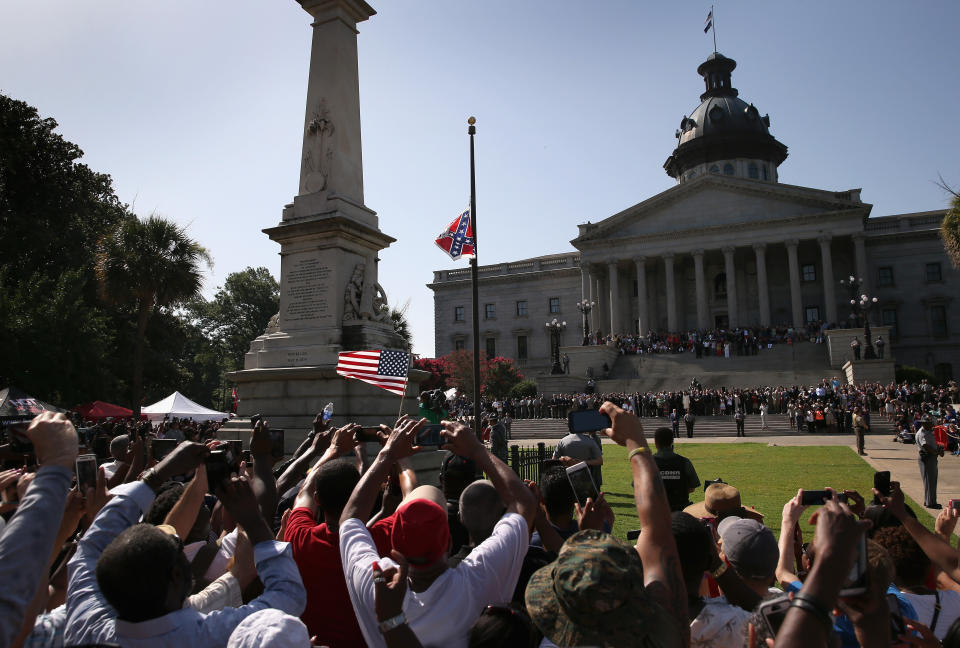  A crowd cheers as a South Carolina state police honor guard lowers the Confederate flag from the Statehouse grounds on July 10, 2015 in Columbia, South Carolina. 