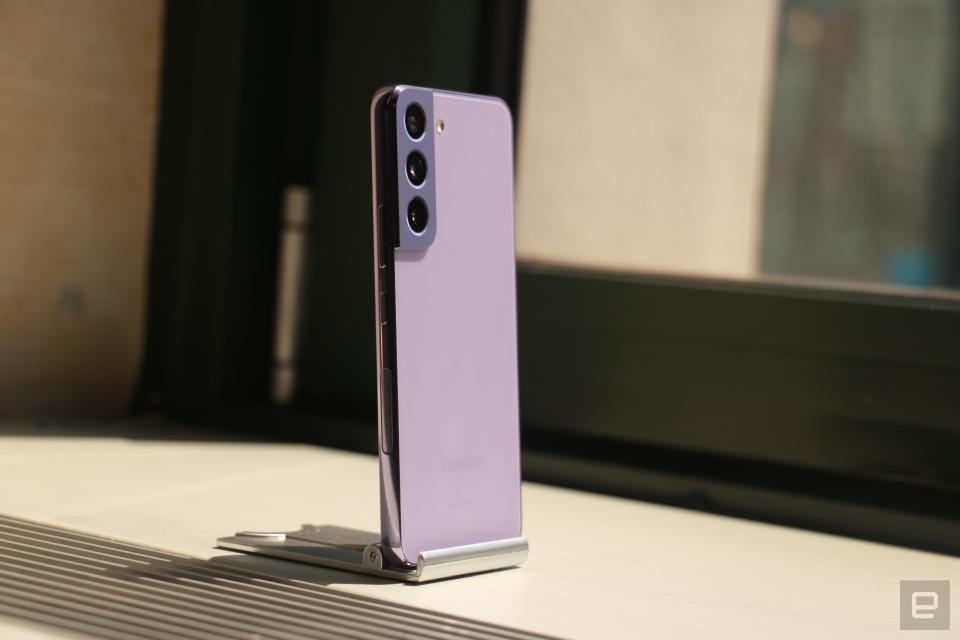 <p>A side view of the Bora Purple Galaxy S22 propped up on a stand with its back facing out, sitting on a window sill, drenched in sunlight.</p>
