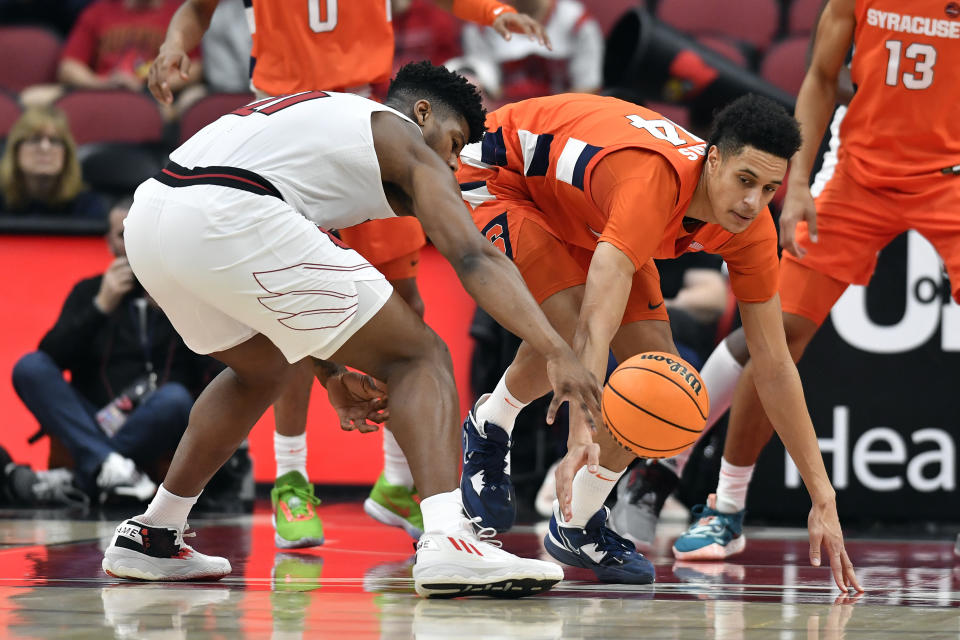 Louisville forward Sydney Curry (21) and Syracuse center Jesse Edwards (14) go after a loose ball during the first half of an NCAA college basketball game in Louisville, Ky., Tuesday, Jan. 3, 2023. (AP Photo/Timothy D. Easley)