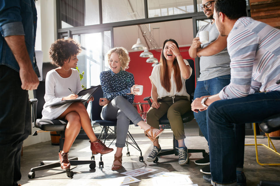 A group of people sit in a circle in an office.