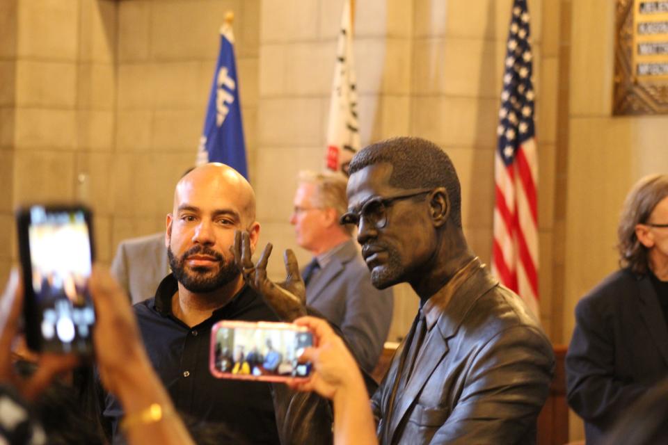 Artist Nathan Murray stands with his bust of Malcolm X at the Nebraska Hall of Fame induction ceremony May 22. 2024.