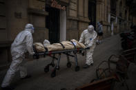 Mortuary workers carry the body of an elderly person who died of COVID-19 after removing it from a nursing home in Barcelona, Spain, Friday, Nov. 13, 2020. (AP Photo/Emilio Morenatti)