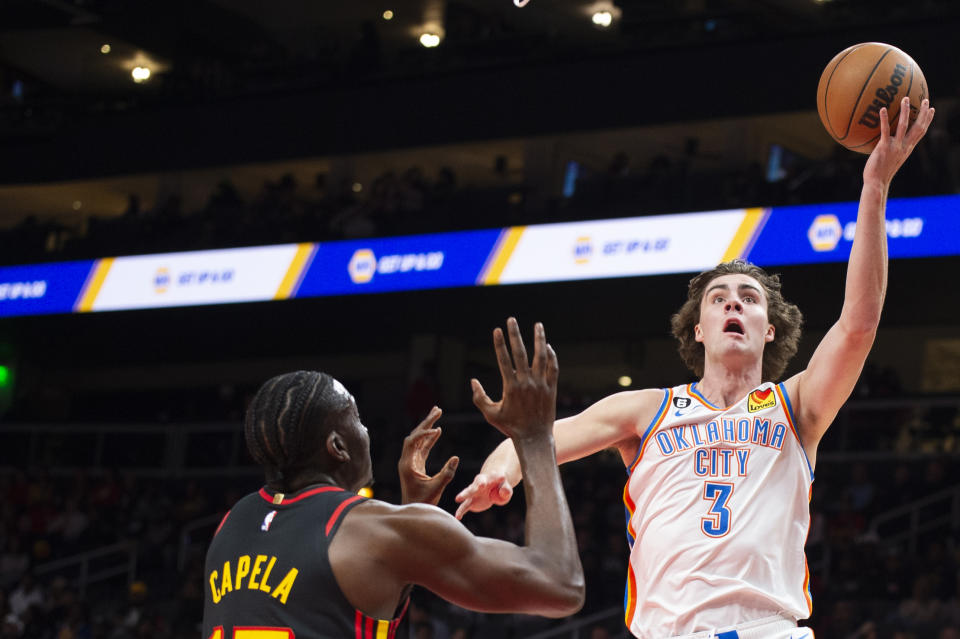 Oklahoma City Thunder guard Josh Giddey shoots against Atlanta Hawks center Clint Capela during the first half of an NBA basketball game, Monday, Dec. 5, 2022, in Atlanta. (AP Photo/Hakim Wright Sr.)