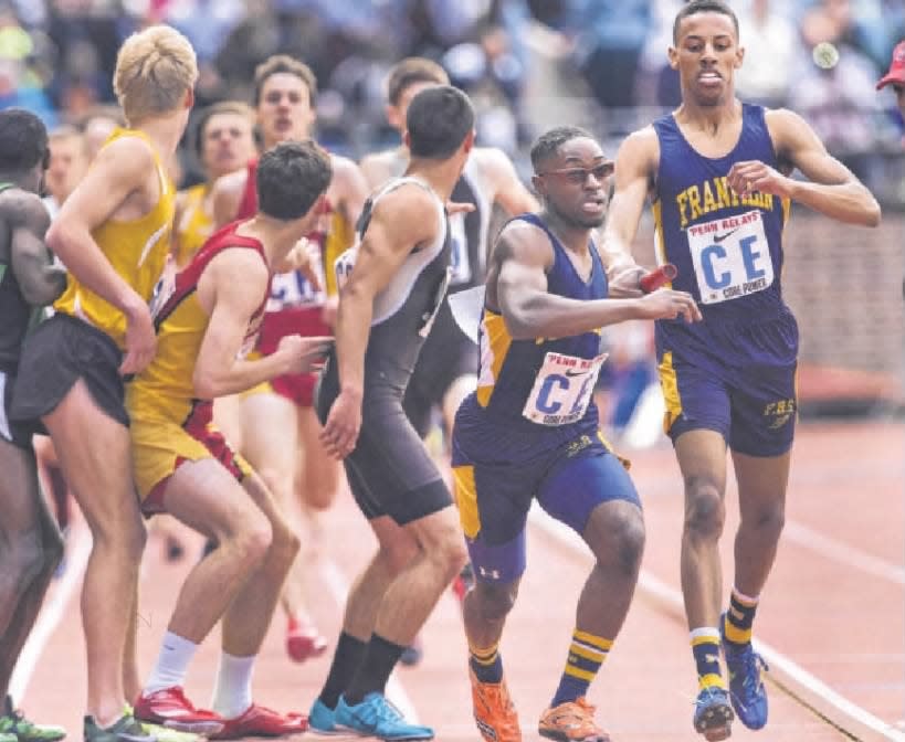 Franklin’s Ross Clarke hands off to Anfernee Joseph in their 4x800 race on Friday, April 25, 2014, at the Penn Relays in Philadelphia.