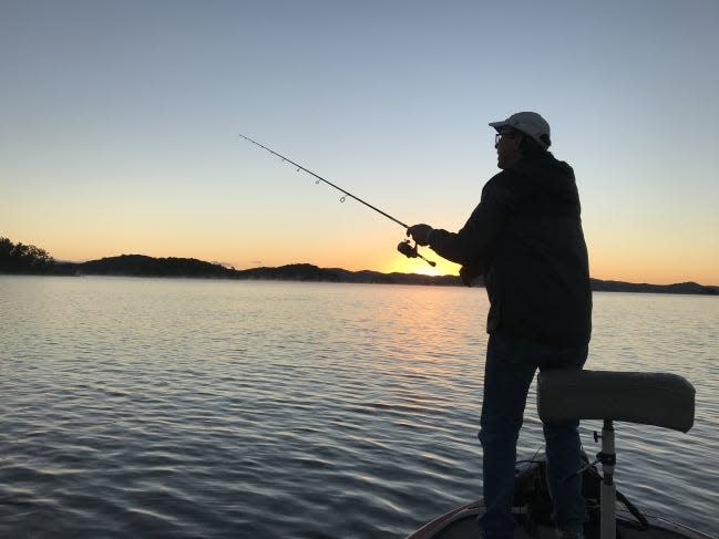 The sun rises on Broken Bow Lake as Mike Newman begins a morning of bass fishing.