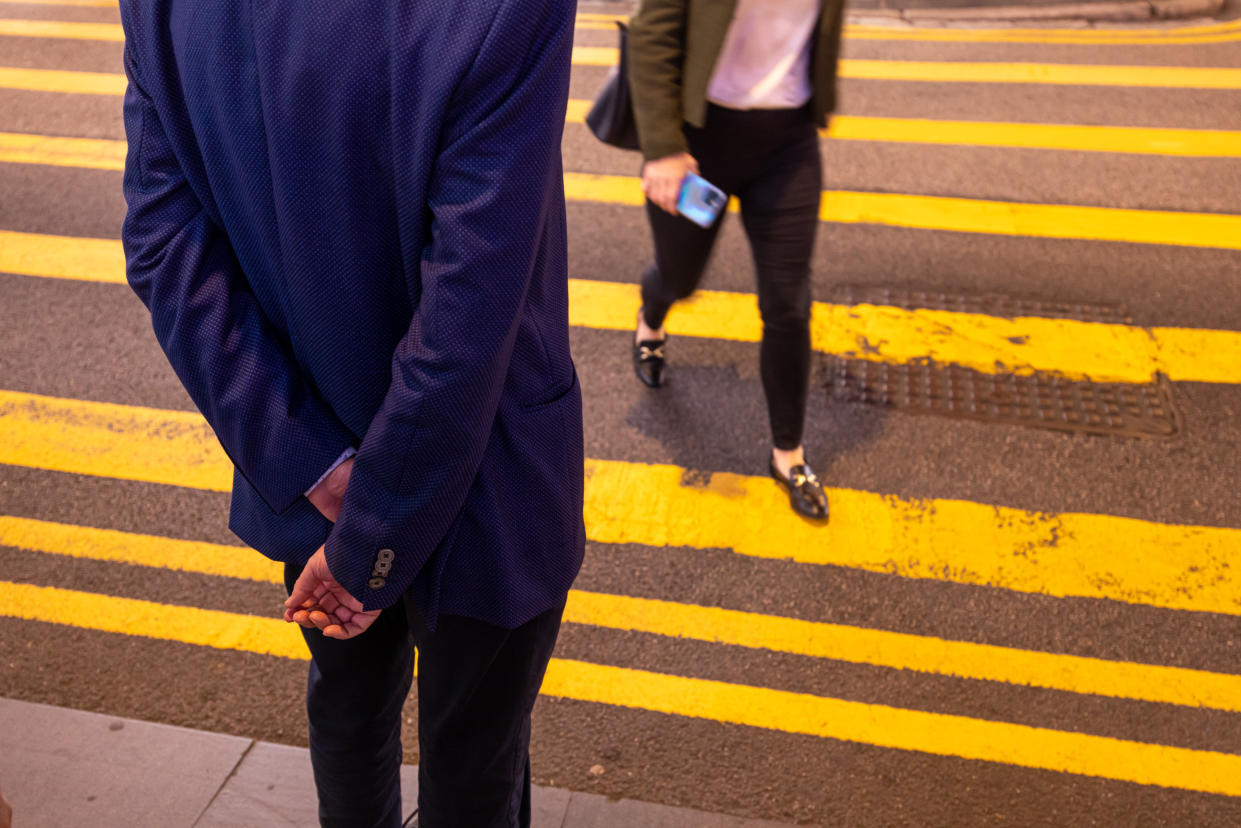 Pedestrians cross a street in the Central district in Hong Kong, China, on Monday, Nov. 20, 2023. Photographer: Paul Yeung/Bloomberg