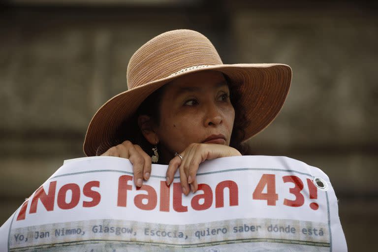 ARCHIVO - Una mujer lleva una pancarta que dice en español "¡Nos faltan 43!", en referencia a los 43 estudiantes desaparecidos de una escuela de maestros rural durante una marcha en la Ciudad de México, el jueves 26 de noviembre de 2015. La Comisión de la Verdad creada para averiguar qué pasó con los estudiantes desaparecidos presentó el jueves 18 de agosto de 2022 un informe que deja entrever la posible responsabilidad del ejército mexicano en la desaparición. (Foto AP/Eduardo Verdugo, Archivo)