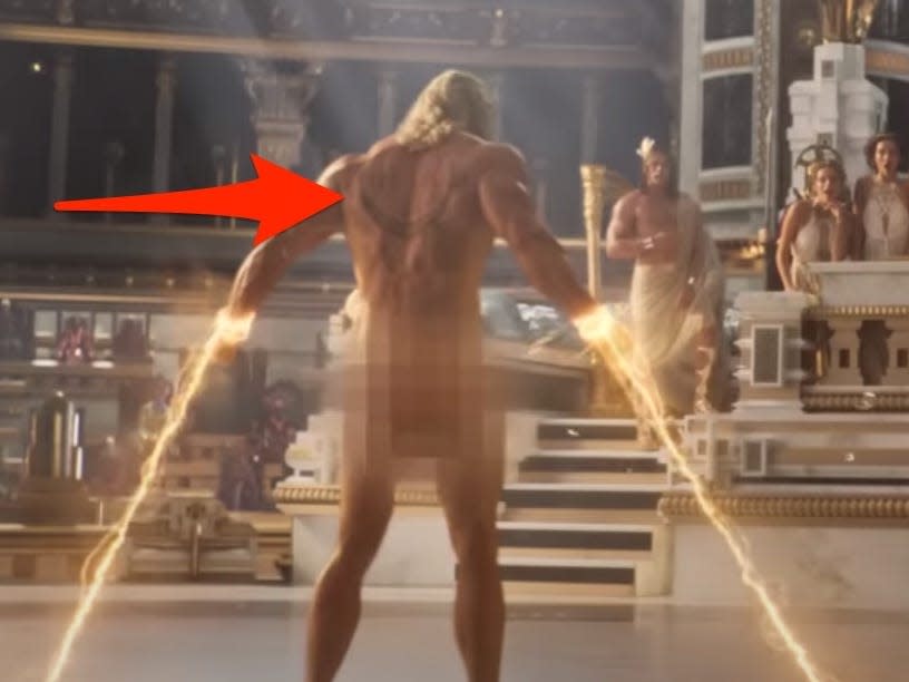 A red arrow pointing to a Loki tattoo on Thor's back in "Thor: Love and Thunder."