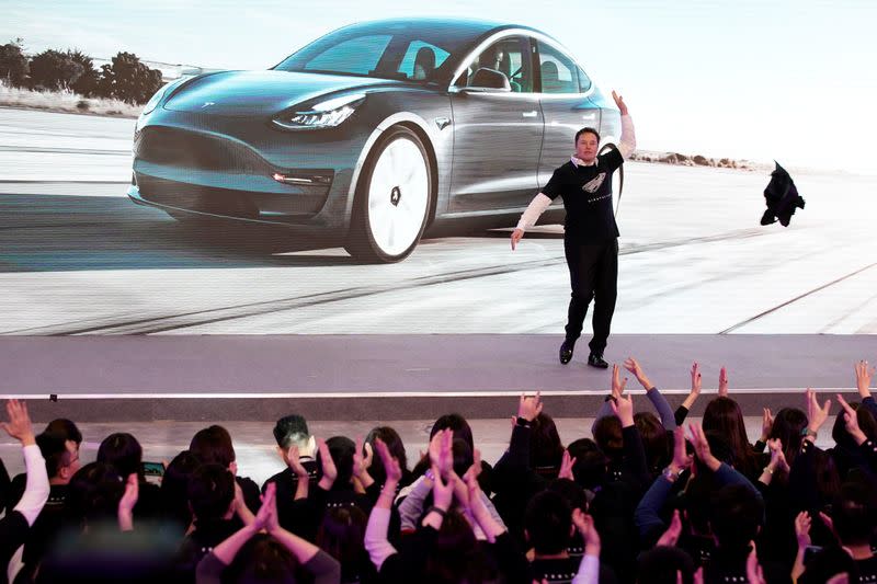 Tesla Inc CEO Elon Musk takes off his coat onstage during a delivery event for Tesla China-made Model 3 cars in Shanghai