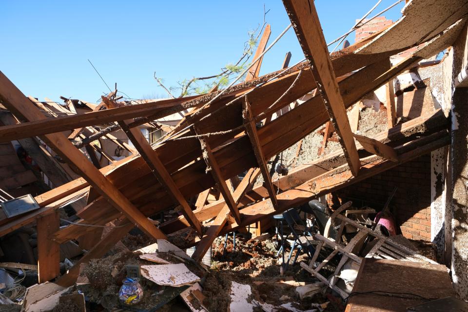 The roof collapsed inside the Norman living room where, Jean Hopkins, 83, normally would have been sitting, but survived in a closet. In the bottom left of the photo is a glass candy jar sitting on a glass table that miraculously survived the damage from the Sunday tornado.