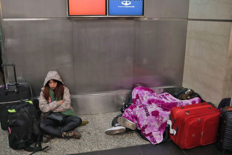 Pasajeros acostados en el piso, adultos mayores sentados hace horas en la misma silla, bebés llorando, caras de cansancio, lágrimas y enojo en el aeroparque metropolitano