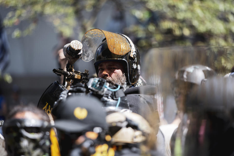 Alan Swinney points a paintball gun at a group of counterprotesters, Saturday, Aug. 22, 2020, in Portland, Ore. Far-right organizers with the stated goal of "saying no to Marxism" clashed with other demonstrators at the Justice Center in Portland, drawing multiple counterprotests from left-wing, anti-fascist groups and Black Lives Matter groups. The top U.S. prosecutor in Oregon on Wednesday, Sept. 30, 2020, rejected a request from Portland's mayor to end the federal deputation of dozens of police officers as part of the response to ongoing protests, saying it was the only way to end “lawlessness.” (Brooke Herbert/The Oregonian via AP)