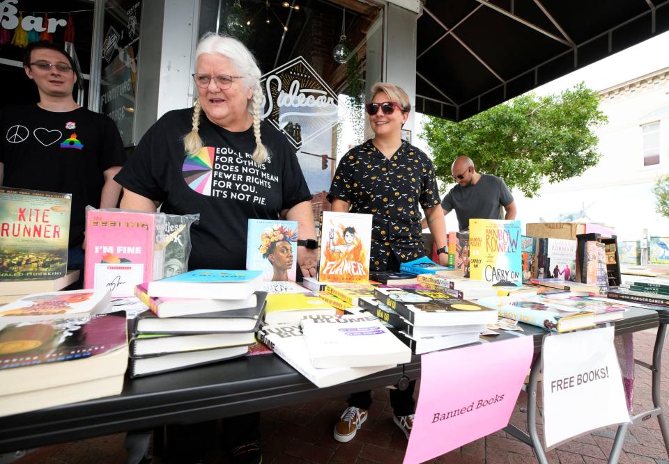 Twice in the past few months, Volusia County Quakers have given away books that have been banned in some schools. DeLand Quaker Cheryl Demers is pictured working the free book table along with other volunteers in downtown DeLand Oct. 7.