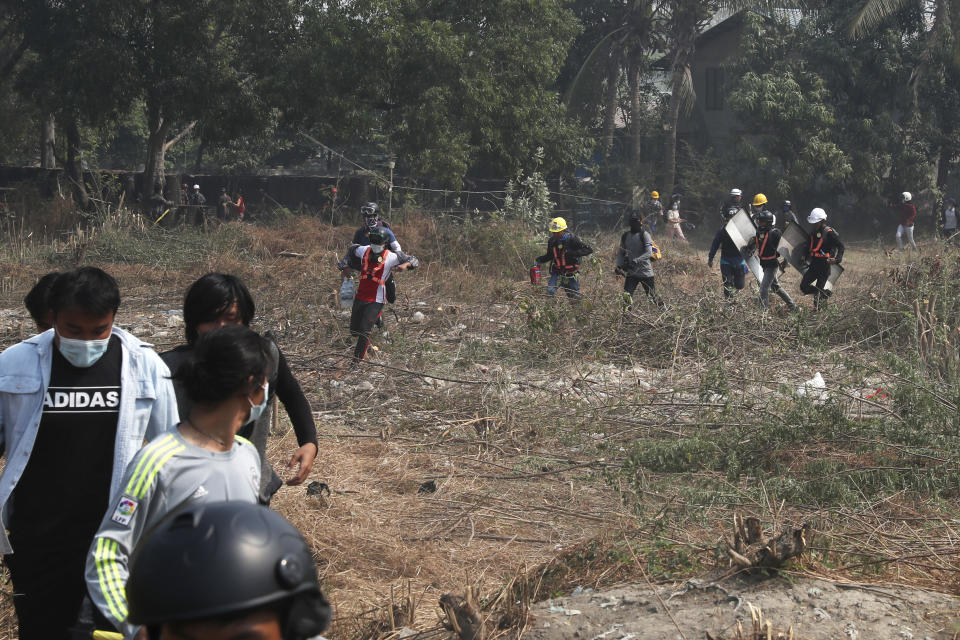 Anti-coup protesters run in an open field after police security forces try to disperse them with tear gas in Mandalay, Myanmar Saturday, March 13, 2021. Police in Myanmar fired rubber bullets and tear gas at protesters in the country's two largest cities and elsewhere on Friday, as authorities continued their harsh crackdown on opponents of last month's military coup. (AP Photo)