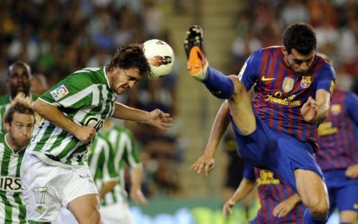 Barcelona's Sergio Busquets (R) fights for the ball with Real Betis' Javier Chica during their Spanish La Liga match at Benito Villamarin stadium in Sevilla. Ten-man Barcelona needed an injury-time goal to secure a 2-2 draw