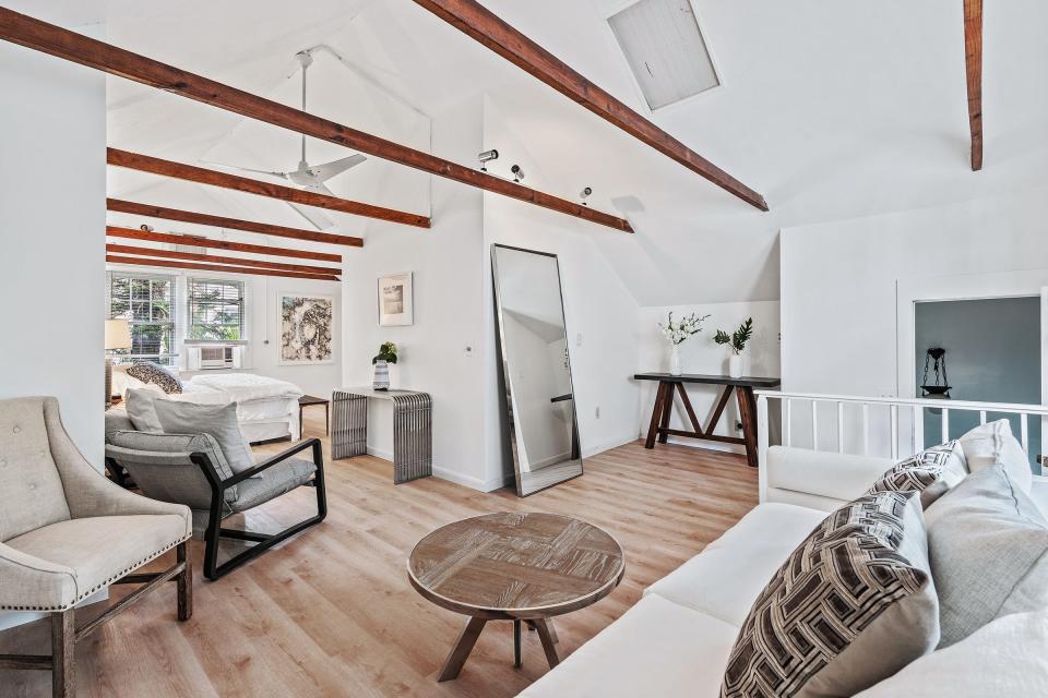 On the second floor with peaked ceilings, the primary bedroom has room for its own seating area.