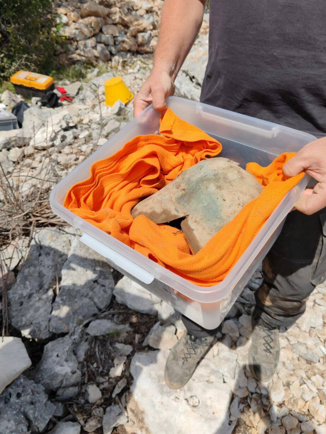 An archaeologist carries the 2,500-year-old helmet.