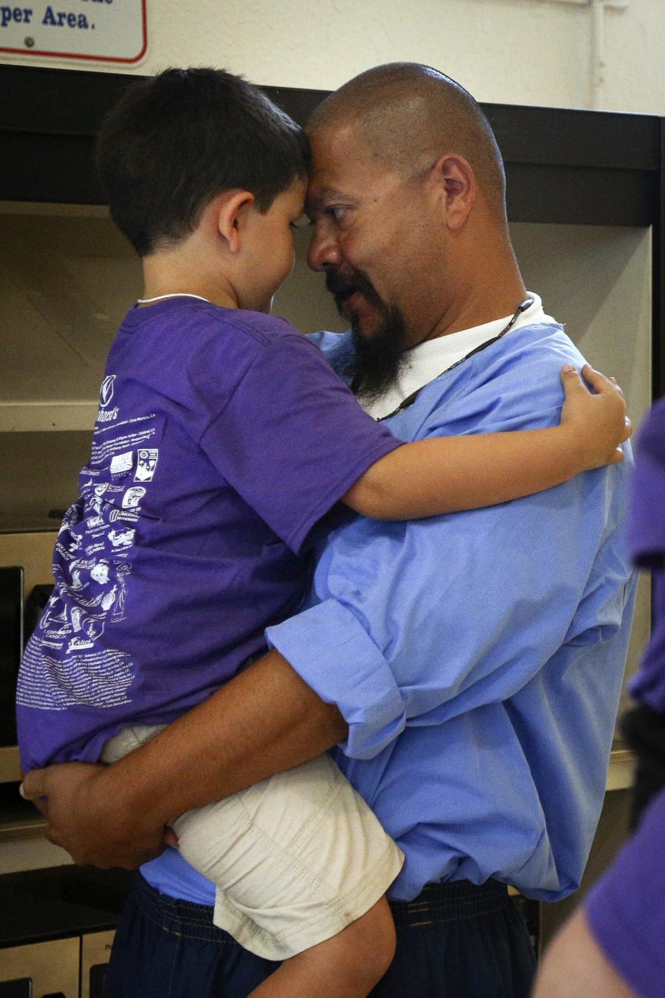 Adrian Navarro holds his son A.J. at the end of a "Get On the Bus" visiting day to Folsom State Prison