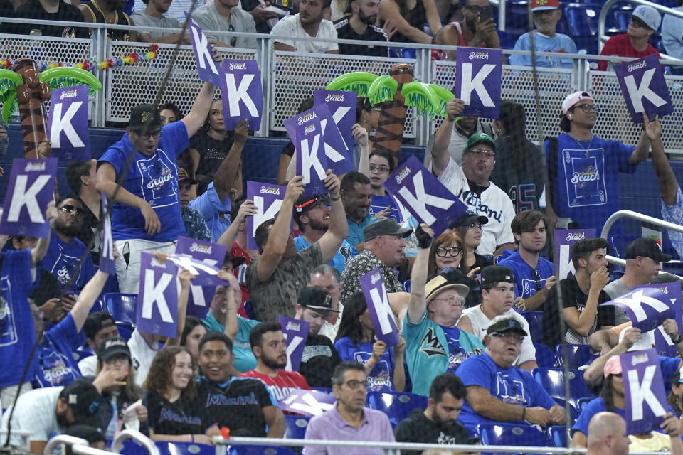 Fans hold up signs after Miami Marlins starting pitcher Sandy Alcantara struck out Philadelphia Phillies' Didi Gregorius during the third inning of a baseball game Friday, July 15, 2022, in Miami. (AP Photo/Lynne Sladky)