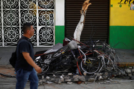 A man walks past broken bicycles, cables and other debris after an earthquake, in Jojutla de Juarez, Mexico September 21, 2017. REUTERS/Edgard Garrido