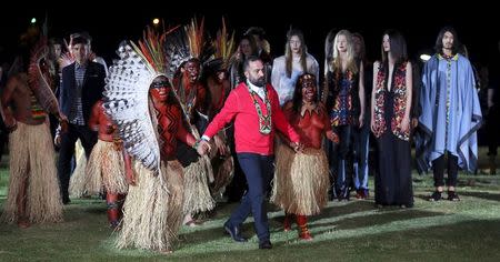 Founder of Cavalera, Alberto Hiar (C), walks with indians of Yawanawa ethnicity after presenting creations from the Cavalera Summer 2016 Ready To Wear collection during Sao Paulo Fashion Week in Sao Paulo April 13, 2015. REUTERS/Paulo Whitaker