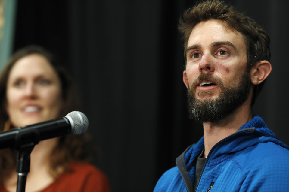 Travis Kauffman responds to questions during a news conference Thursday, Feb. 14, 2019, in Fort Collins, Colo., about his encounter with a mountain lion while running a trail just west of Fort Collins last week. Kaufman's girlfriend, Annie Bierbower, looks on at left. (AP Photo/David Zalubowski)